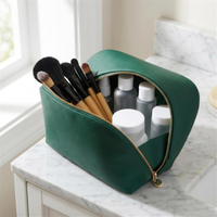 Emerald pouch open with brushes on marble vanity 4K